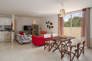Un salon moderne comprenant un canapé, une table à manger et un coin cuisine.