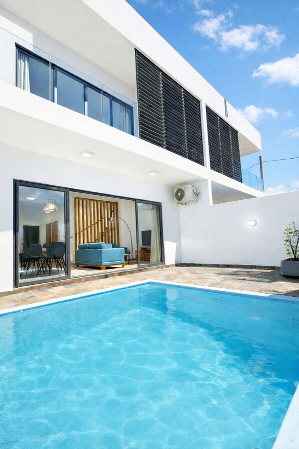 A modern house with a swimming pool, large windows, and a flat roof. - Ocean Blue Villa with private pool at Flic-en-Flac (Flic en Flac)