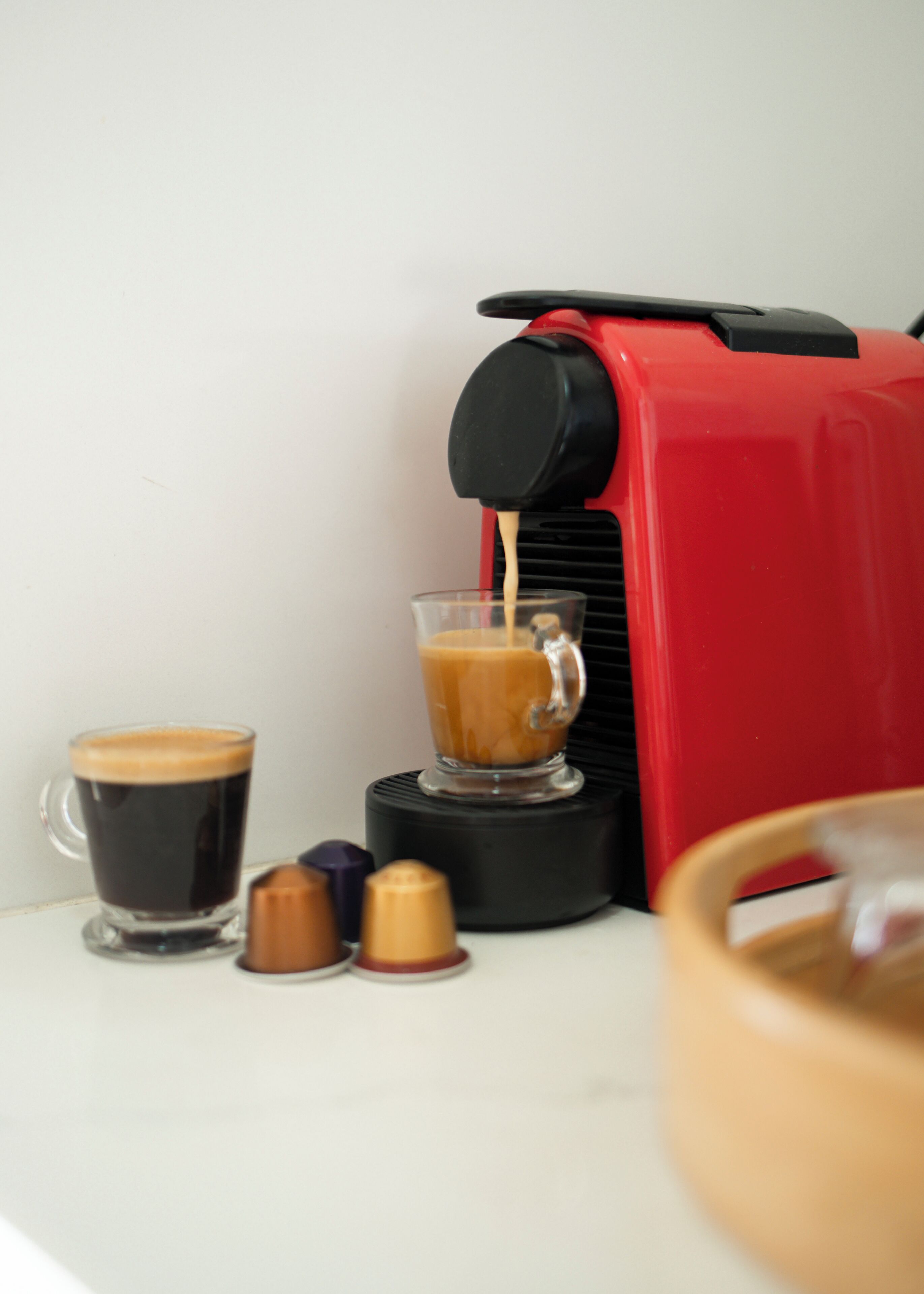 A coffee machine dispensing coffee into a glass cup.