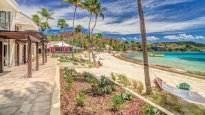 Un hôtel situé en bord de mer, doté d’un patio, de palmiers et offrant une vue sur l’océan.