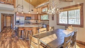 Une cuisine spacieuse avec des meubles en bois, un grand îlot central et un lustre.