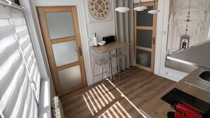 Eine moderne Küche mit Holzboden, einem eingebauten Herd und einer Essecke mit Barhocker.