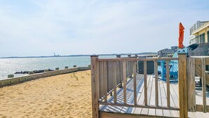 Un pontile in legno con una spiaggia sabbiosa e vista sull'acqua.