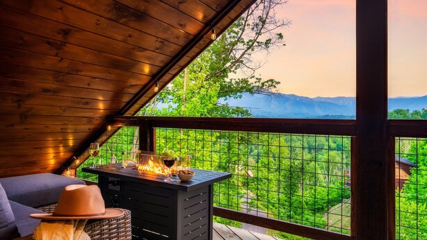 Une terrasse en bois avec une cheminée, un panier en osier et un chapeau.