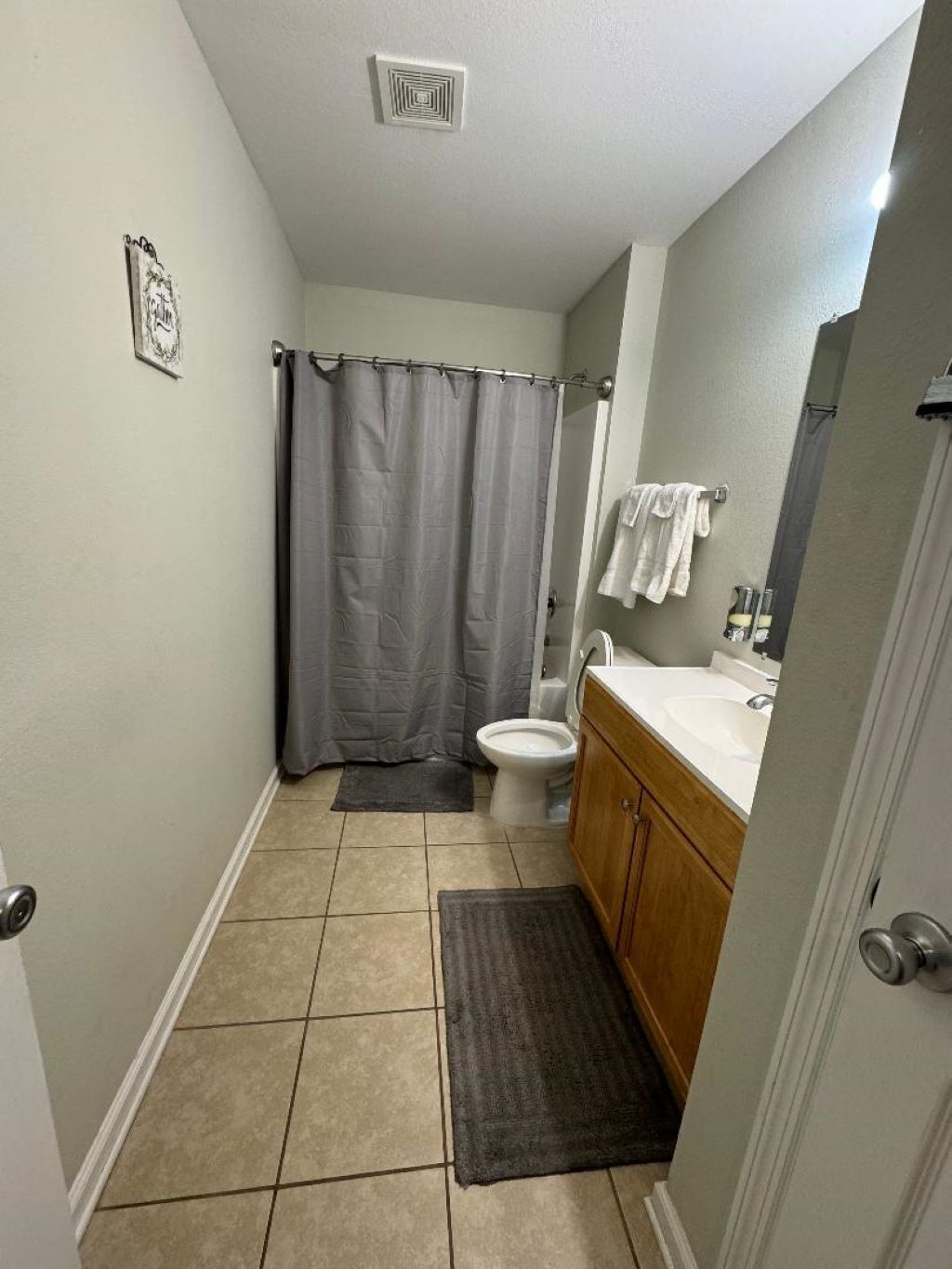 A small bathroom with a toilet, sink, and shower curtain.