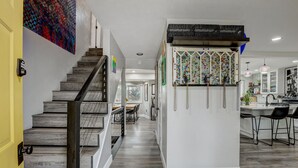 Une cuisine moderne dotée d’un îlot central, de tabourets de bar et d’un coin repas avec des chaises.
