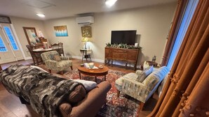 Una sala de estar con un sofá, sillones, una mesa de centro, un televisor y una chimenea.