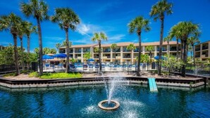 Ein Hotel mit Pool, Palmen und einer Springbrunnen.