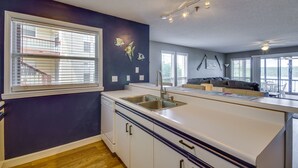 A modern kitchen with a large island, built-in appliances, and a view to the living area. - Osage Beach Condo w/ Private Deck & Lake Views! (Osage Beach)