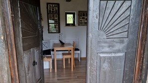 A rustic wooden door leading into a room with a wooden floor, a table with chairs, and a wall with framed pictures. - Cottage with whirlpool and sauna (Stara Gora)