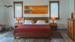Un dormitorio con cama de madera, dos lámparas de noche, un ventilador de techo y un cuadro en la pared.