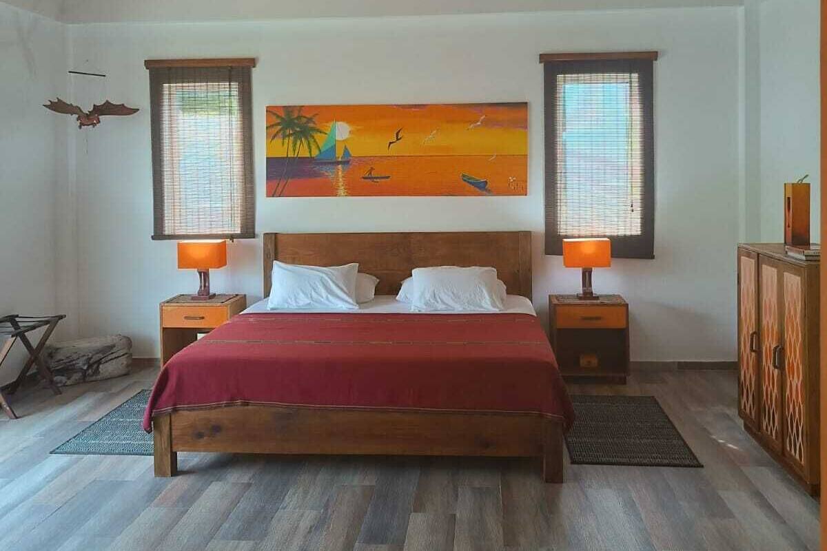Ein Schlafzimmer mit einem Holzbett, zwei Nachttischlampen, einem Deckenventilator und einem Bild an der Wand.