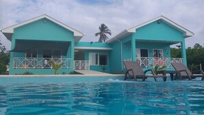 Un edificio de dos pisos con piscina delantera.