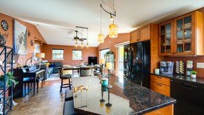 A spacious kitchen with a central island, wooden cabinets, and modern appliances.