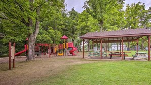 A playground with slides and climbing structures, surrounded by trees and picnic tables. - Grandma's House LA 1-bedroom apartment just 22 minutes to Lake Michigan (Lake Ann)