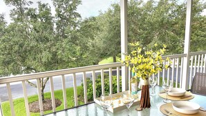 A dining table set for four with white plates, cutlery, and a vase of yellow flowers. - Bright, Safe, Comfortable 3Bdrm in Bradenton, FL.  Pool, Tennis, Golf,  Beaches. (Bradenton)