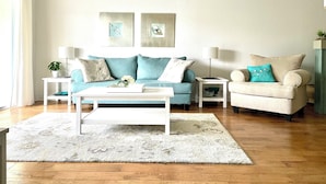 A modern living room with a sofa, a coffee table, and a side table. - Bright, Safe, Comfortable 3Bdrm in Bradenton, FL.  Pool, Tennis, Golf,  Beaches. (Bradenton)