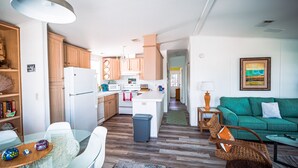 Una cucina moderna con mobili in legno, un'isola centrale e un'area pranzo con tavolo in vetro.