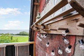 A rustic wooden structure with a series of hanging light bulbs.