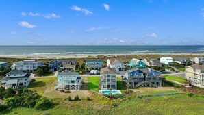 A coastal residential area with houses near the beach, featuring a swimming pool and a view of the ocean. - "DemmMarsh-Uns" is a 4 Bedroom, 3.5 Bathroom Home w/ a Private Pool and Elevator! (Holden Beach)
