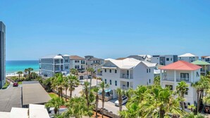 A coastal hotel with multiple buildings, a beach view, and palm trees.