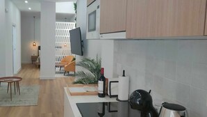 A modern living space with a sofa, dining table, and kitchen area. - Carmen Street, Seville, Historic Center B3 (Sevilla)