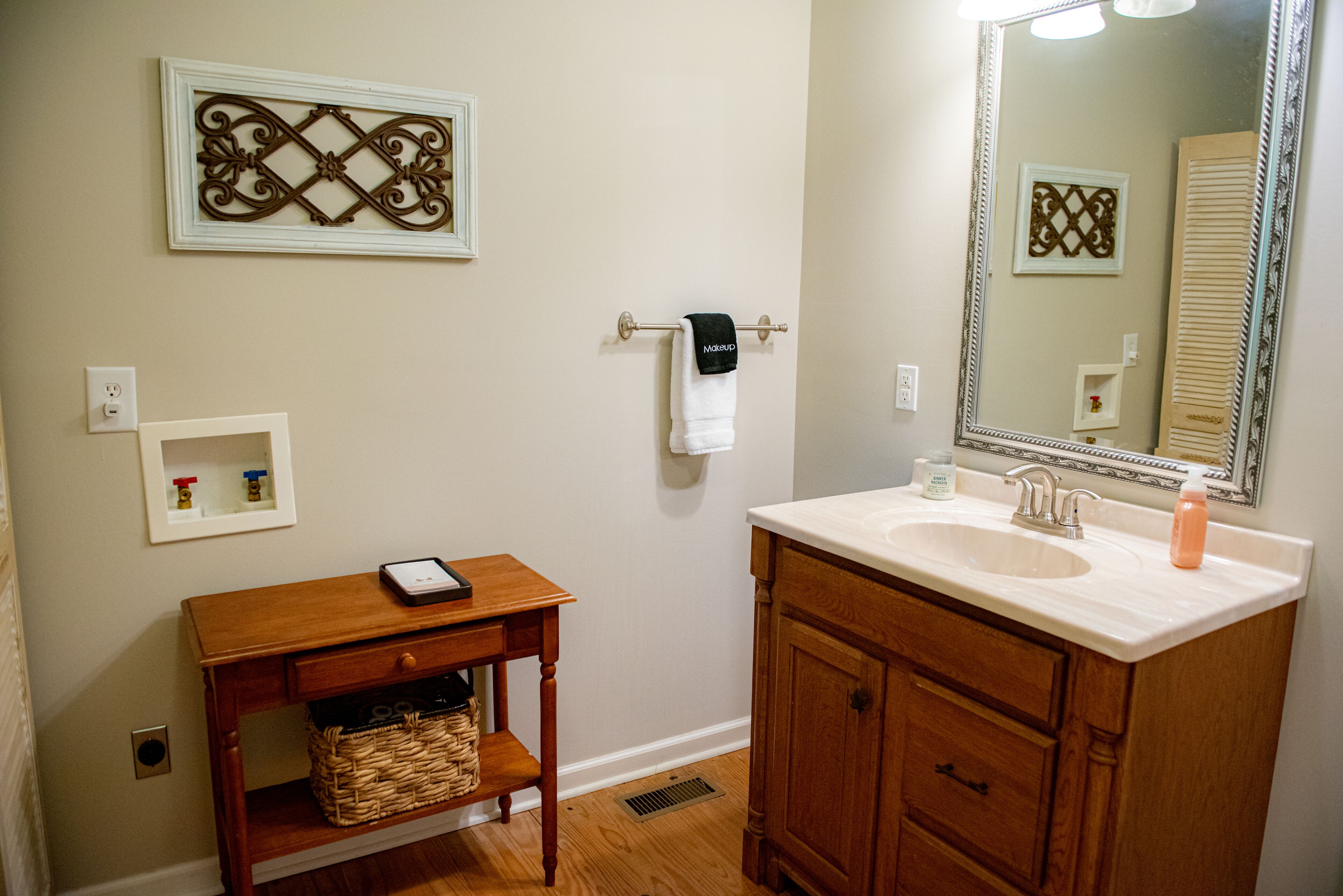 Une salle de bain avec un meuble-lavabo en bois, un grand miroir et un lavabo.