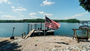 Een steiger met een Amerikaanse vlag, een houten terras en uitzicht op een meer.