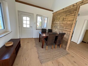 Ein Essbereich mit Holztisch und Stühlen, einer Bank und einem Fenster mit Blick.