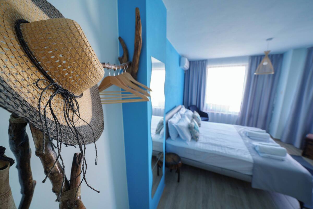 Une pièce comprenant un lit, un fauteuil suspendu et une sculpture en bois.
