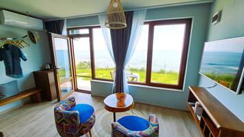 Habitación doble Deluxe, vista al mar | Área de sala de estar | Televisión LED de 43 pulgadas con canales digitales y televisión