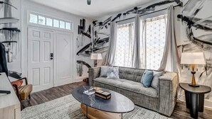 Un salon moderne avec un canapé, une table basse et un ventilateur de plafond.