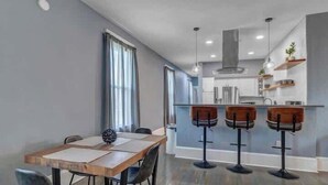 A modern kitchen with a central island, bar stools, and pendant lighting. - Gigantic duplex in Springfield (Jacksonville)