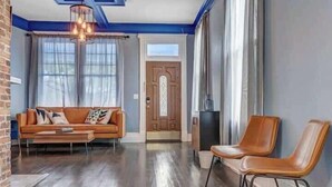 A living room with a sofa, two chairs, a coffee table, a chandelier, and a door with a window. - Gigantic duplex in Springfield (Jacksonville)