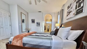 Una camera da letto con un letto grande, una testiera in legno e vista sul corridoio.