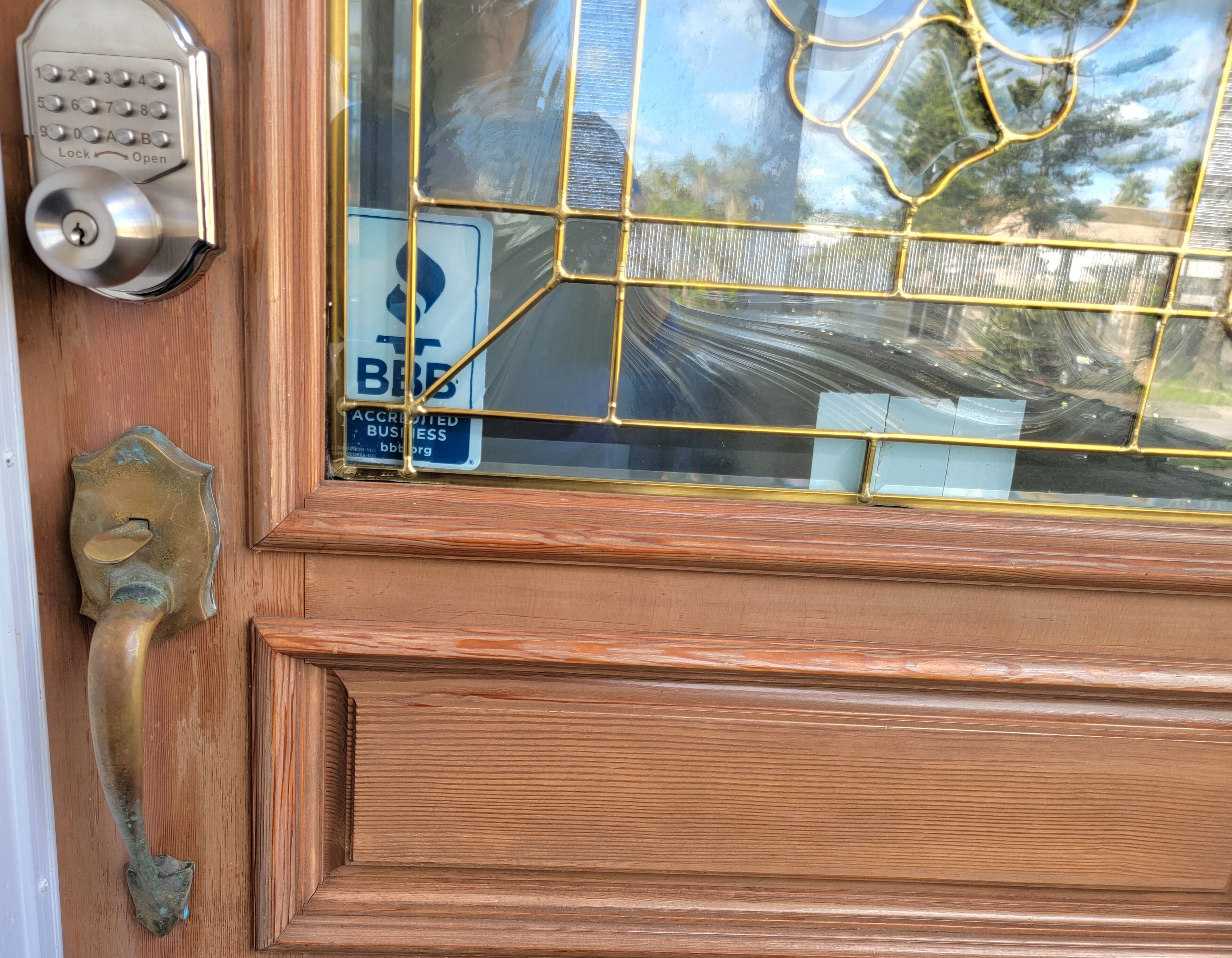 Une porte en bois avec une poignée de porte en laiton et un système de verrouillage à clavier.
