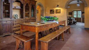 Un'area pranzo rustica con un tavolo di legno, panche e un'esposizione di fiori.