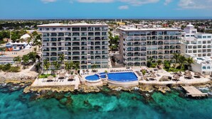 A resort with multiple buildings, a pool area, and a view of the ocean. - 
7th-Floor Oceanfront Oasis: 4BR/4BA, Dive Pier & Walk to Town! (San Miguel de Cozumel)
