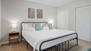 Un dormitorio ordenado con cama, mesitas de noche y un armario.