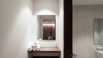 A bathroom with a mirror, a sink, a towel rack, and a toilet.