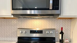 A kitchen with a stainless steel microwave, oven, and stove.