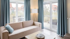 Ein modernes Wohnzimmer mit einem beigen Sofa, einem Holztisch und einer Lampe.