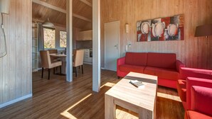 Ein geräumiger Wohnbereich mit einem roten Sofa, einem Holztisch und einem Bild an der Wand.