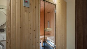 Un sauna en bois, doté d’un banc et d’un panneau de commande.