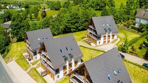 A residential area with multiple two-story houses featuring sloped roofs and balconies. - Spacious, modern apartment, near center (Winterberg)