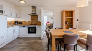 Una cocina moderna con armarios blancos, una encimera de madera y un horno empotrado.