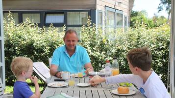 Et spisebord med tallerkener, glas og en appelsinjuiceflaske.