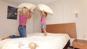 A bedroom with a bed, a nightstand, and a wall-mounted light fixture. - Pet-Friendly Retreat (Kootwijk)