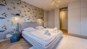 A modern bedroom with a large bed, a wardrobe, and a wall decorated with fish decals. - Apartment in Domburg near the Beach (Domburg)