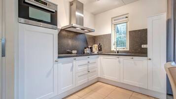 Een koelkast, een koffiezetapparaat/waterkoker, eettafels